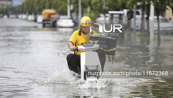 People travel in the rain in Huai'an, China, on September 14, 2024. 