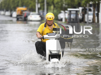 People travel in the rain in Huai'an, China, on September 14, 2024. (