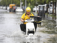 People travel in the rain in Huai'an, China, on September 14, 2024. (