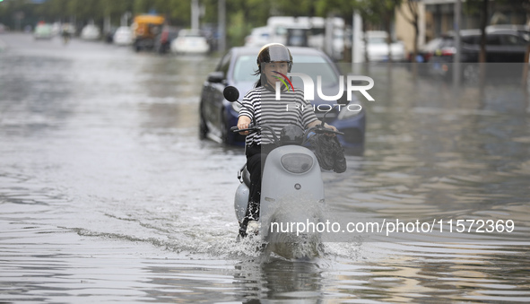 People travel in the rain in Huai'an, China, on September 14, 2024. 