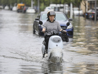 People travel in the rain in Huai'an, China, on September 14, 2024. (