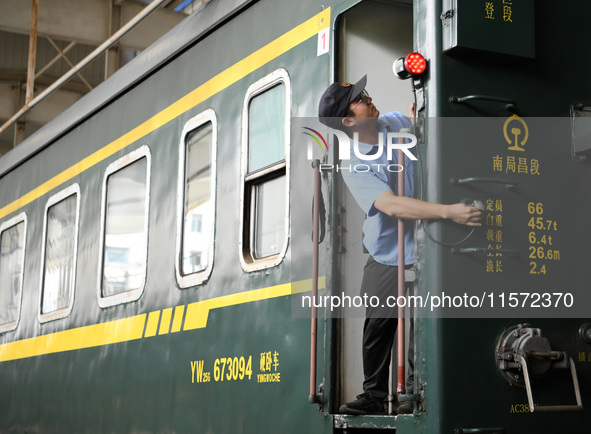 Workers inspect a bullet train in Jiujiang, China, on September 13, 2024. 