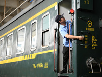 Workers inspect a bullet train in Jiujiang, China, on September 13, 2024. (