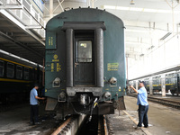 Workers inspect a bullet train in Jiujiang, China, on September 13, 2024. (