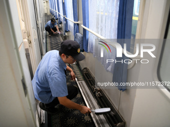 Workers inspect a bullet train in Jiujiang, China, on September 13, 2024. (