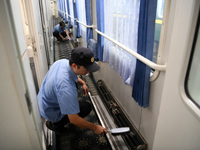 Workers inspect a bullet train in Jiujiang, China, on September 13, 2024. (