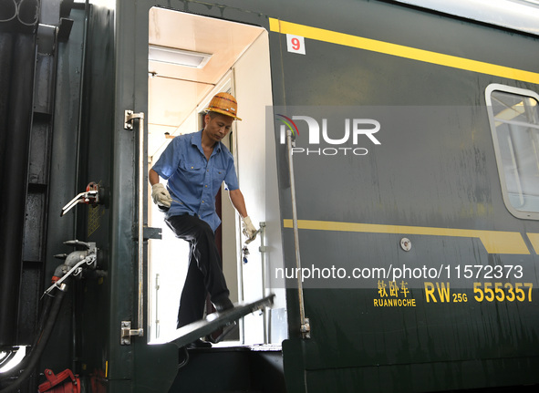 Workers inspect a bullet train in Jiujiang, China, on September 13, 2024. 