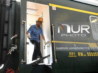 Workers inspect a bullet train in Jiujiang, China, on September 13, 2024. (