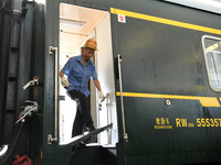 Workers inspect a bullet train in Jiujiang, China, on September 13, 2024. (