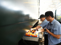 Workers inspect a bullet train in Jiujiang, China, on September 13, 2024. (