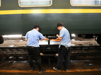 Workers inspect a bullet train in Jiujiang, China, on September 13, 2024. (