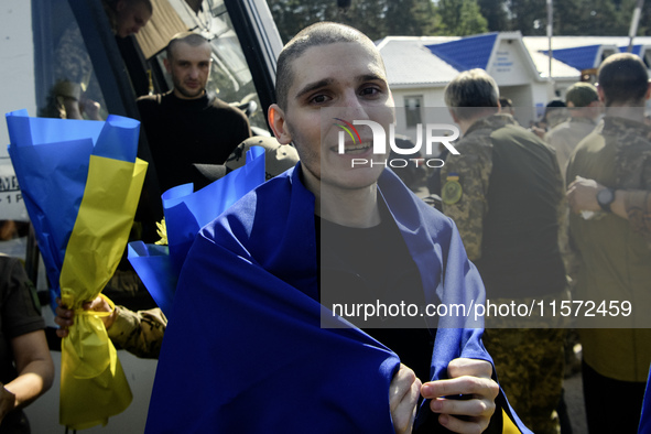 Ukrainian prisoners of war (POWs) react as they exit a bus as forty-nine civilian and military Ukrainians return to Ukraine from captivity i...