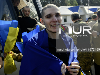 Ukrainian prisoners of war (POWs) react as they exit a bus as forty-nine civilian and military Ukrainians return to Ukraine from captivity i...