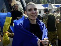 Ukrainian prisoners of war (POWs) react as they exit a bus as forty-nine civilian and military Ukrainians return to Ukraine from captivity i...