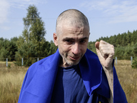 A Ukrainian prisoner of war (POW) reacts as he exits a bus as forty-nine civilian and military Ukrainians return to Ukraine from captivity i...