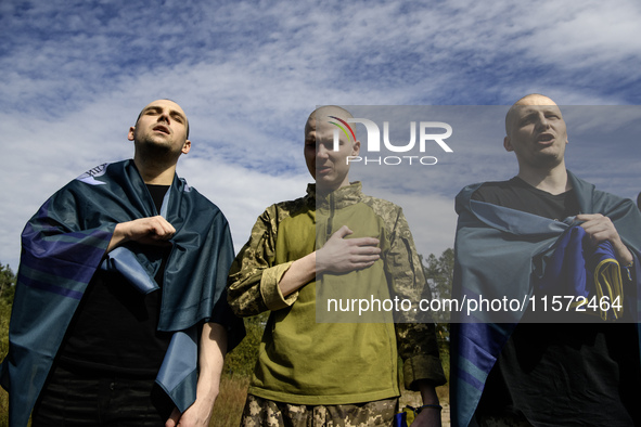 Ukrainian prisoners of war (POWs) sing the Ukrainian anthem as forty-nine civilian and military Ukrainians return to Ukraine from captivity...