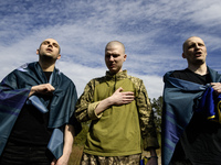 Ukrainian prisoners of war (POWs) sing the Ukrainian anthem as forty-nine civilian and military Ukrainians return to Ukraine from captivity...