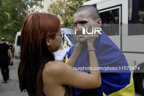 A relative hugs a Ukrainian prisoner of war (POW) who returns from captivity as forty-nine civilian and military Ukrainians return to Ukrain...