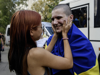 A relative hugs a Ukrainian prisoner of war (POW) who returns from captivity as forty-nine civilian and military Ukrainians return to Ukrain...