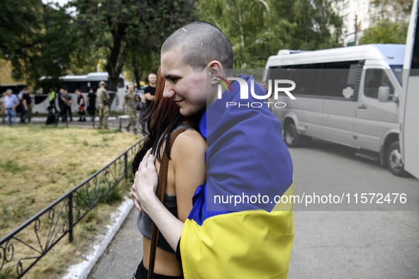 A relative hugs a Ukrainian prisoner of war (POW) who returns from captivity as forty-nine civilian and military Ukrainians return to Ukrain...