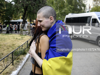 A relative hugs a Ukrainian prisoner of war (POW) who returns from captivity as forty-nine civilian and military Ukrainians return to Ukrain...