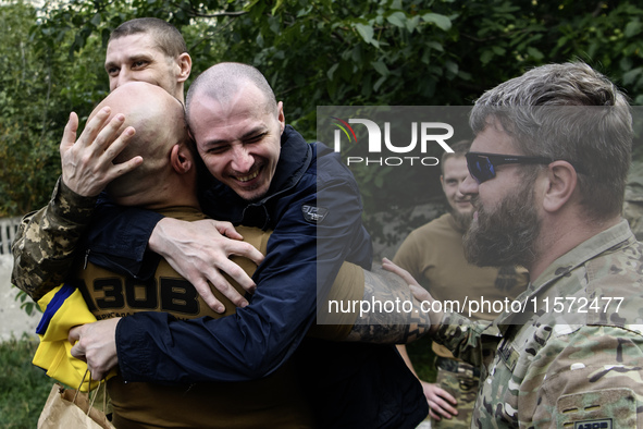 A fellow soldier hugs a Ukrainian prisoner of war (POW) who returns from captivity as forty-nine civilian and military Ukrainians return to...