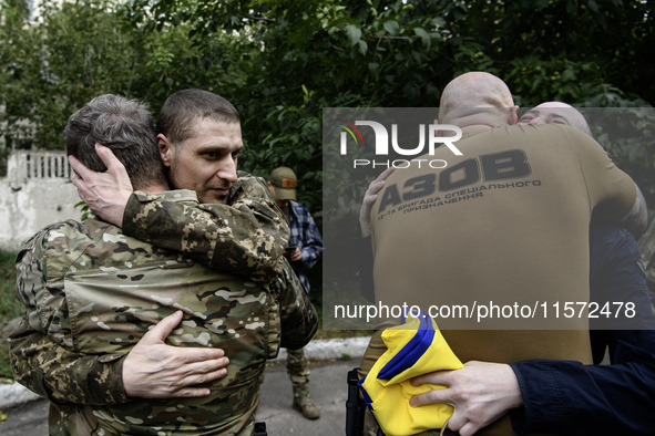 A fellow soldier hugs a Ukrainian prisoner of war (POW) who returns from captivity as forty-nine civilian and military Ukrainians return to...