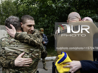 A fellow soldier hugs a Ukrainian prisoner of war (POW) who returns from captivity as forty-nine civilian and military Ukrainians return to...