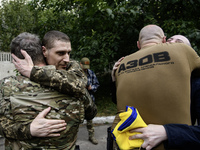 A fellow soldier hugs a Ukrainian prisoner of war (POW) who returns from captivity as forty-nine civilian and military Ukrainians return to...