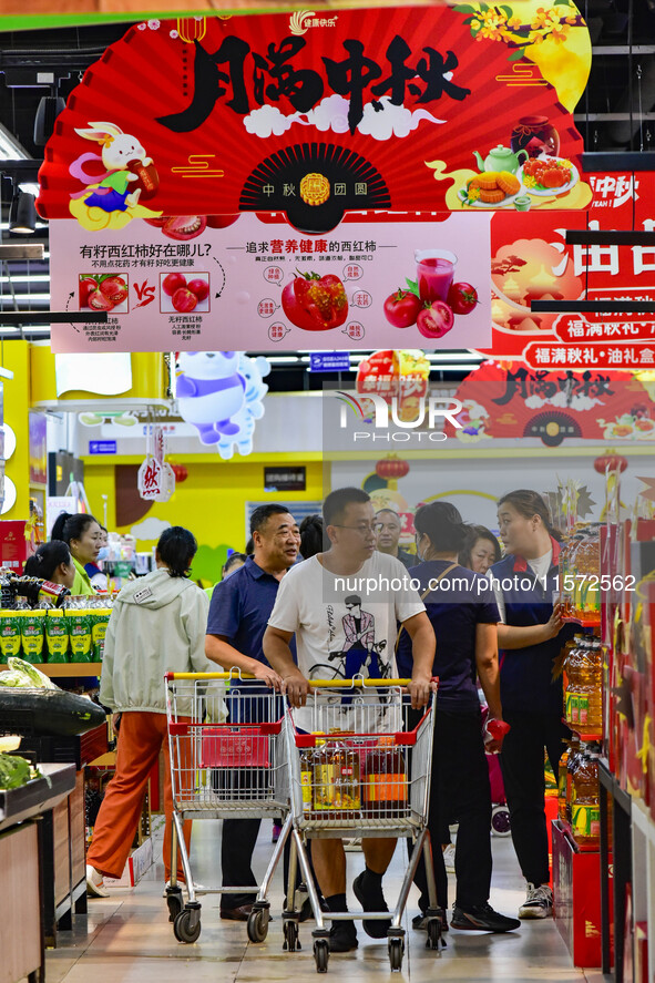 Consumers shop at a supermarket in Qingzhou, China, on September 9, 2024. On September 14, 2024, the National Bureau of Statistics releases...