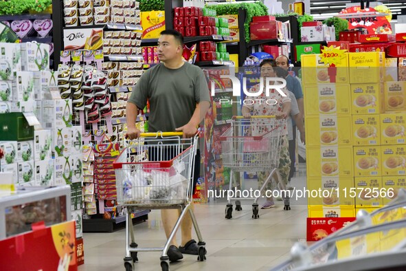 Consumers shop at a supermarket in Qingzhou, China, on September 9, 2024. On September 14, 2024, the National Bureau of Statistics releases...