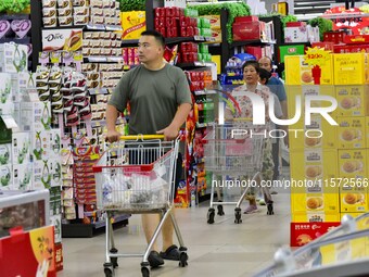 Consumers shop at a supermarket in Qingzhou, China, on September 9, 2024. On September 14, 2024, the National Bureau of Statistics releases...