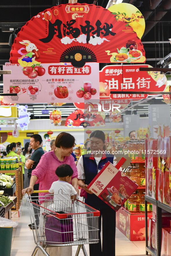 Consumers shop at a supermarket in Qingzhou, China, on September 9, 2024. On September 14, 2024, the National Bureau of Statistics releases...