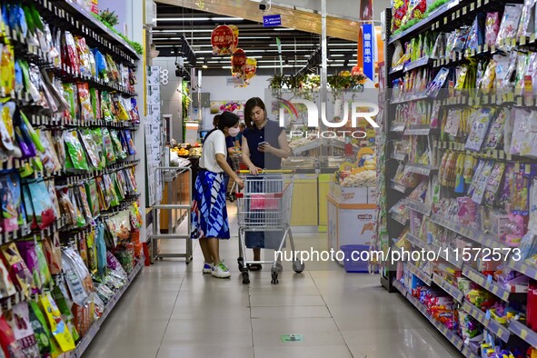 Consumers shop at a supermarket in Qingzhou, China, on September 9, 2024. On September 14, 2024, the National Bureau of Statistics releases...