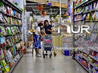 Consumers shop at a supermarket in Qingzhou, China, on September 9, 2024. On September 14, 2024, the National Bureau of Statistics releases...