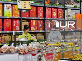 Consumers shop at a supermarket in Qingzhou, China, on September 9, 2024. On September 14, 2024, the National Bureau of Statistics releases...