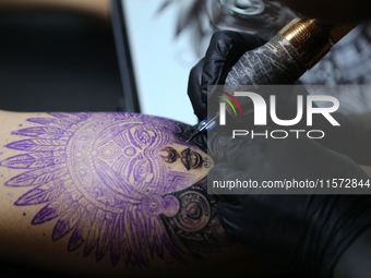 An artist inks a tattoo on the body of an enthusiast during the Himalayan Tattoo Convention in Lalitpur, Nepal, on August 14, 2024. The tatt...