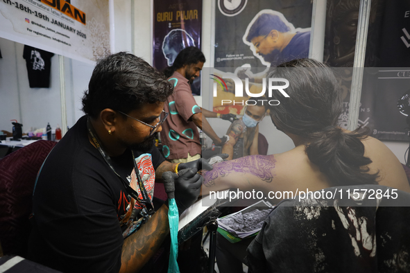 An artist inks a tattoo on the body of an enthusiast during the Himalayan Tattoo Convention in Lalitpur, Nepal, on August 14, 2024. The tatt...