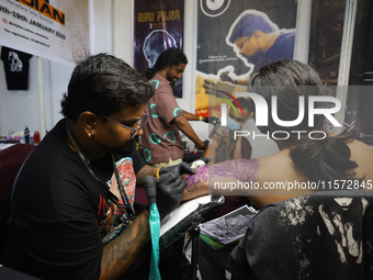 An artist inks a tattoo on the body of an enthusiast during the Himalayan Tattoo Convention in Lalitpur, Nepal, on August 14, 2024. The tatt...