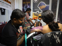 An artist inks a tattoo on the body of an enthusiast during the Himalayan Tattoo Convention in Lalitpur, Nepal, on August 14, 2024. The tatt...