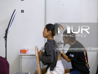 An artist (R) inks a tattoo on the body of an enthusiast (L) during the Himalayan Tattoo Convention in Lalitpur, Nepal, on August 14, 2024....