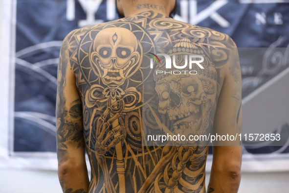 A person poses for a photo showing his tattooed body during the Himalayan Tattoo Convention in Lalitpur, Nepal, on August 14, 2024. The tatt...