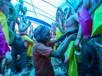 An artist puts a dress and jewelry on the idol of the Hindu lord Bishwokarma, the main craftsman and architect of the gods, at a workshop in...