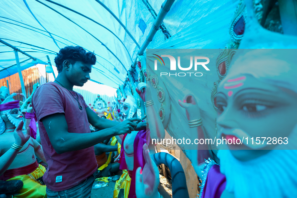 An artist decorates the idol of Hindu lord Bishwokarma, the main craftsman and architect of gods, at a workshop in Lalitpur, Nepal, on Septe...