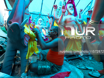 An artist decorates the idol of Hindu lord Bishwokarma, the main craftsman and architect of gods, at a workshop in Lalitpur, Nepal, on Septe...