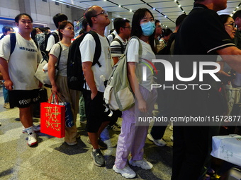 A large number of passengers prepare to travel at Yichang East Railway Station during the Mid-Autumn Festival holiday in Yichang, China, on...