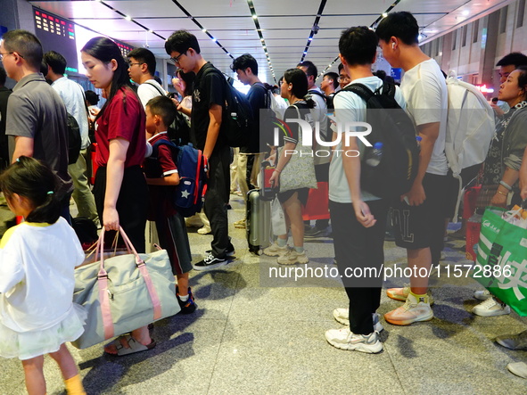 A large number of passengers prepare to travel at Yichang East Railway Station during the Mid-Autumn Festival holiday in Yichang, China, on...