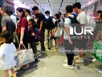 A large number of passengers prepare to travel at Yichang East Railway Station during the Mid-Autumn Festival holiday in Yichang, China, on...