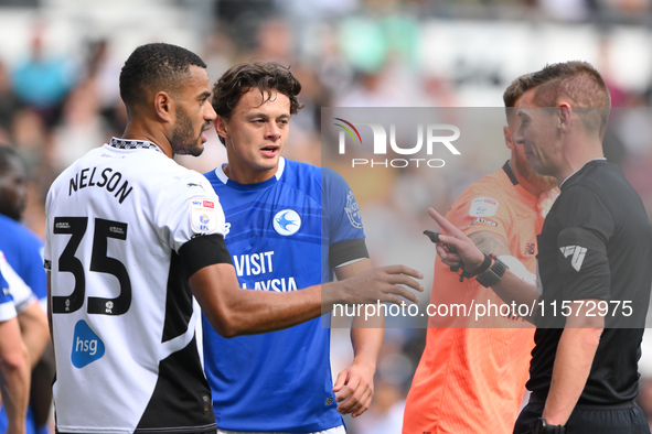 Referee Matthew Donohue has words with Curtis Nelson of Derby County and Perry Ng of Cardiff City during the Sky Bet Championship match betw...