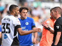 Referee Matthew Donohue has words with Curtis Nelson of Derby County and Perry Ng of Cardiff City during the Sky Bet Championship match betw...